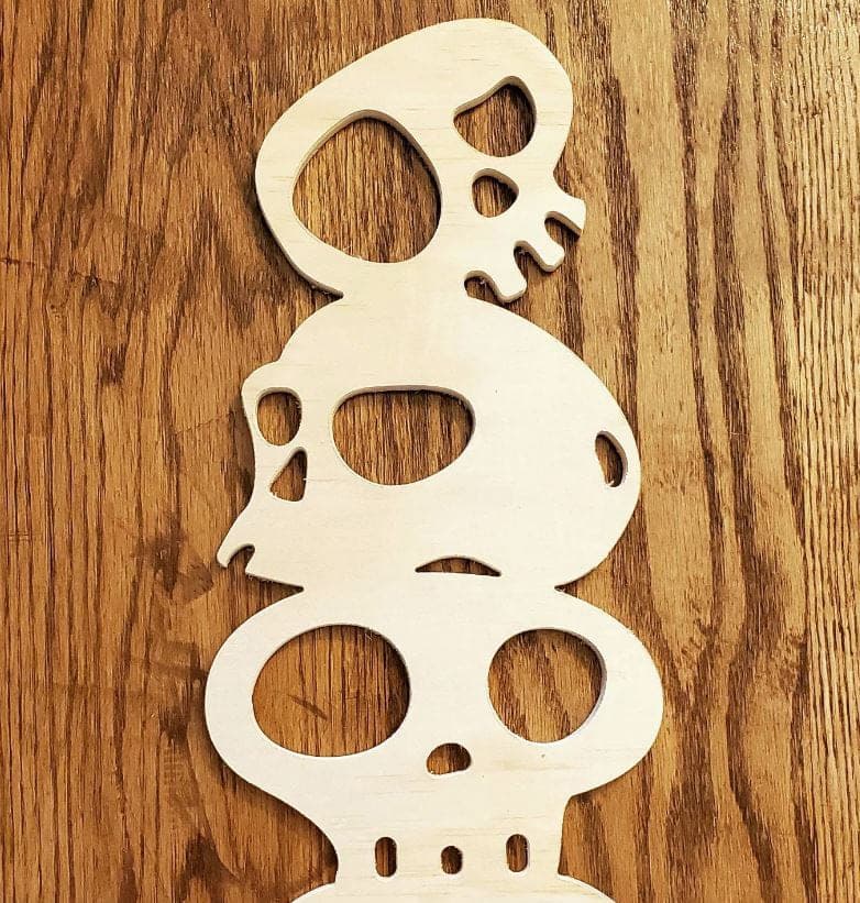 Stacked skull shapes cut from plywood on the CNC