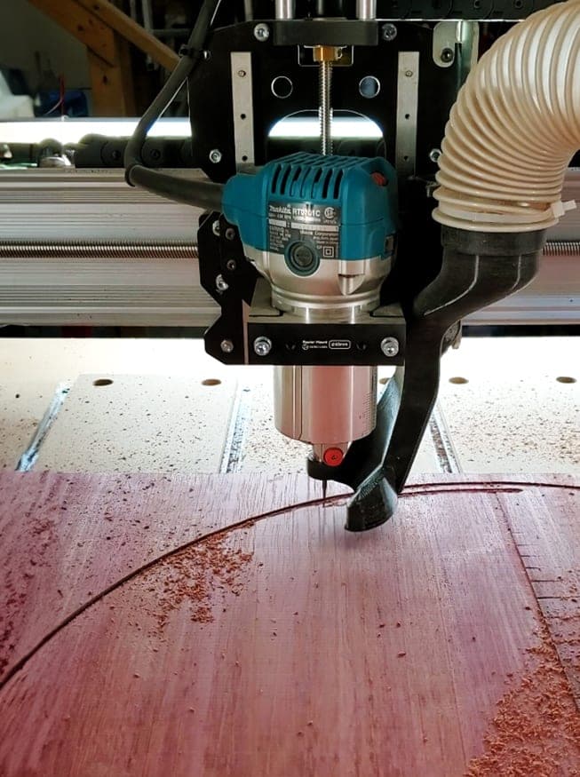CNC router carving a design into a wood slab