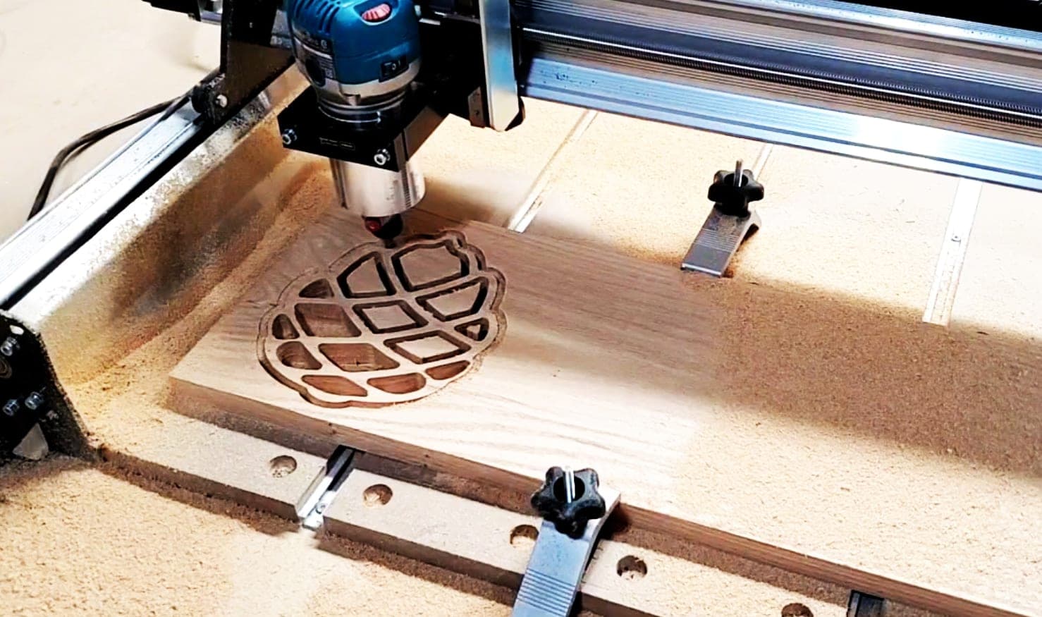 CNC router cutting a decorative lattice pattern into a panel