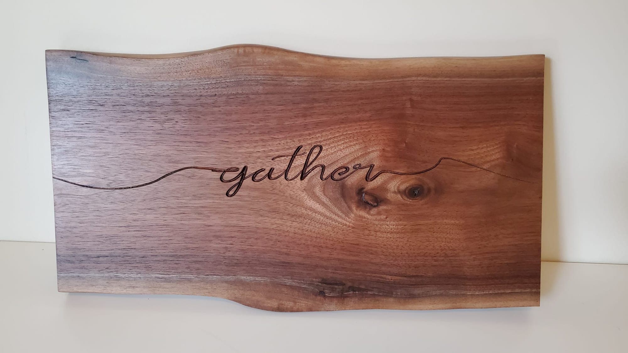 Walnut live-edge sign engraved with the word gather