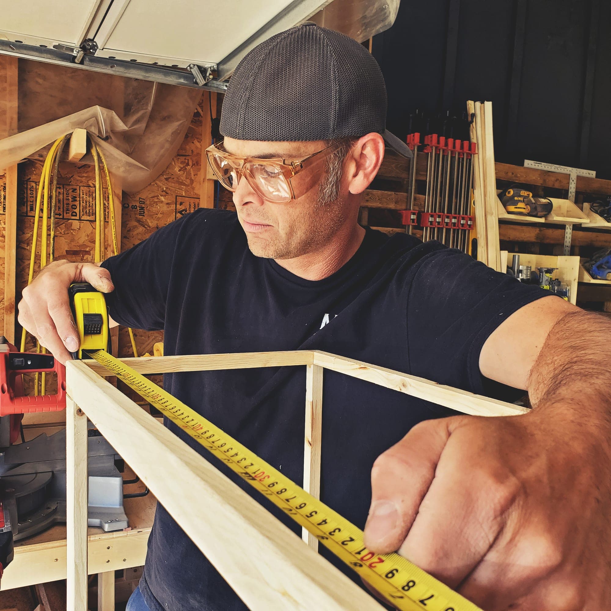 Lee measuring a frame with a tape measure