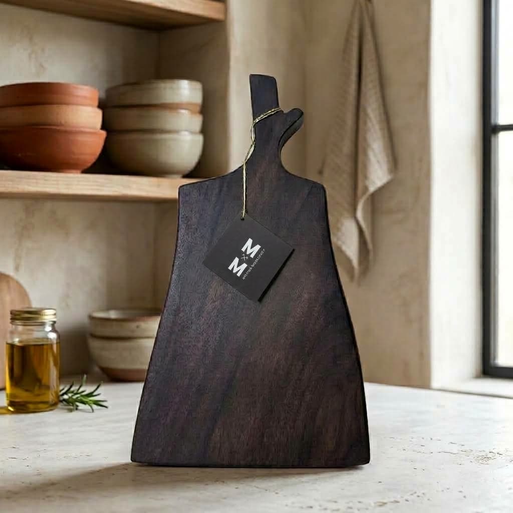 Walnut Bower black walnut board with a forked-branch handle and Moose Mill tag, standing on a kitchen counter
