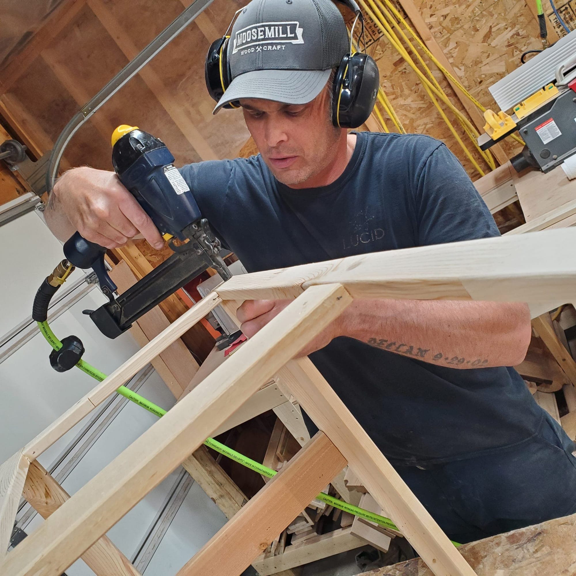 Lee using a nail gun to assemble a project in the shop